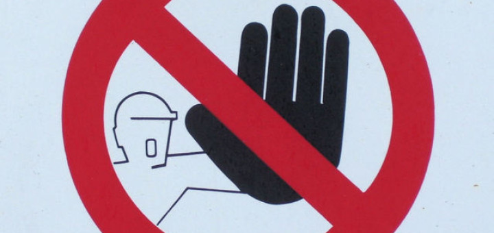 A hand raise in a blocking motion, with a red circle around it and a red slash bisecting it
