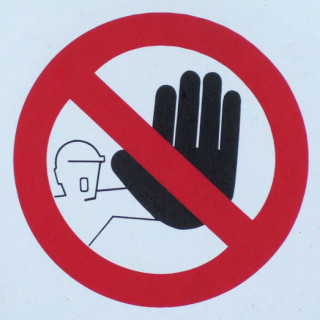 A hand raise in a blocking motion, with a red circle around it and a red slash bisecting it