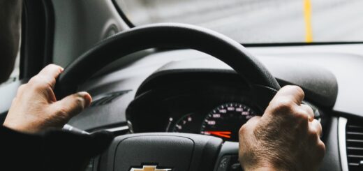 A close-up of hands on a car steering wheel